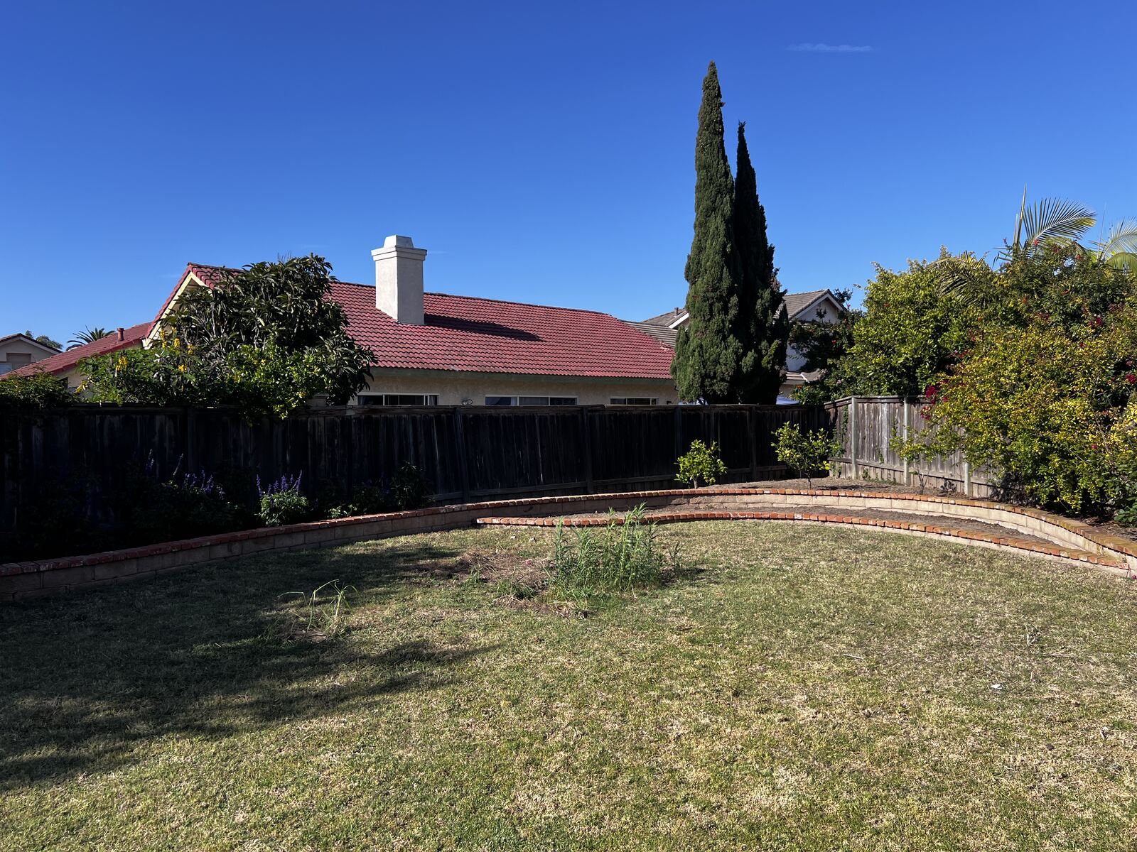 Same backyard as open lawn after play structure removal