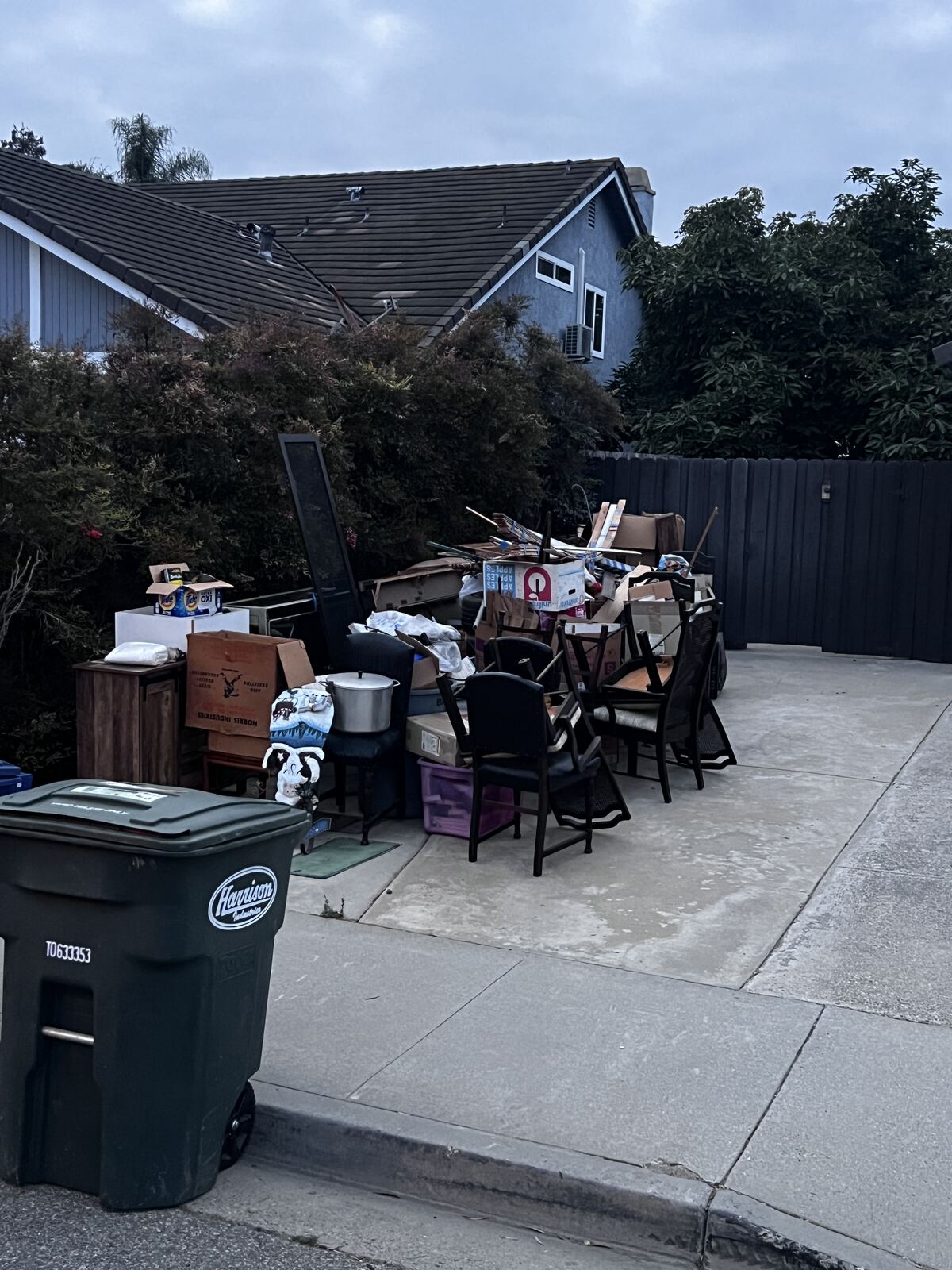 Driveway piled with furniture and boxes set out for removal